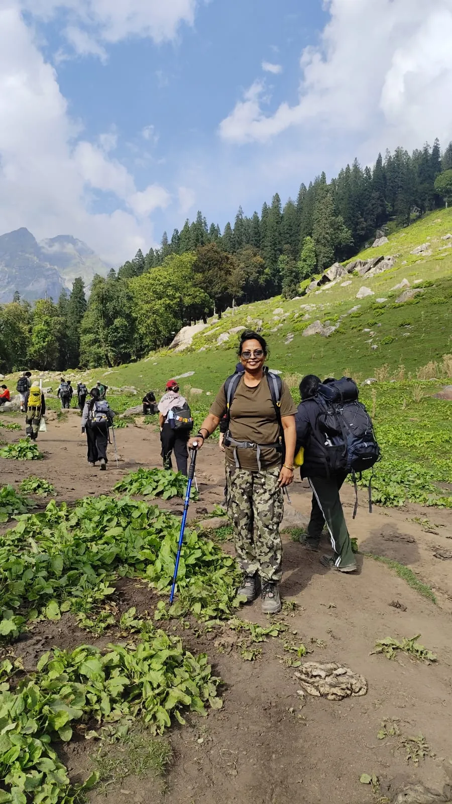 Roseleen Sharma with a trekking pole on the green meadow trail towards Chika on the Hampta Pass Trek