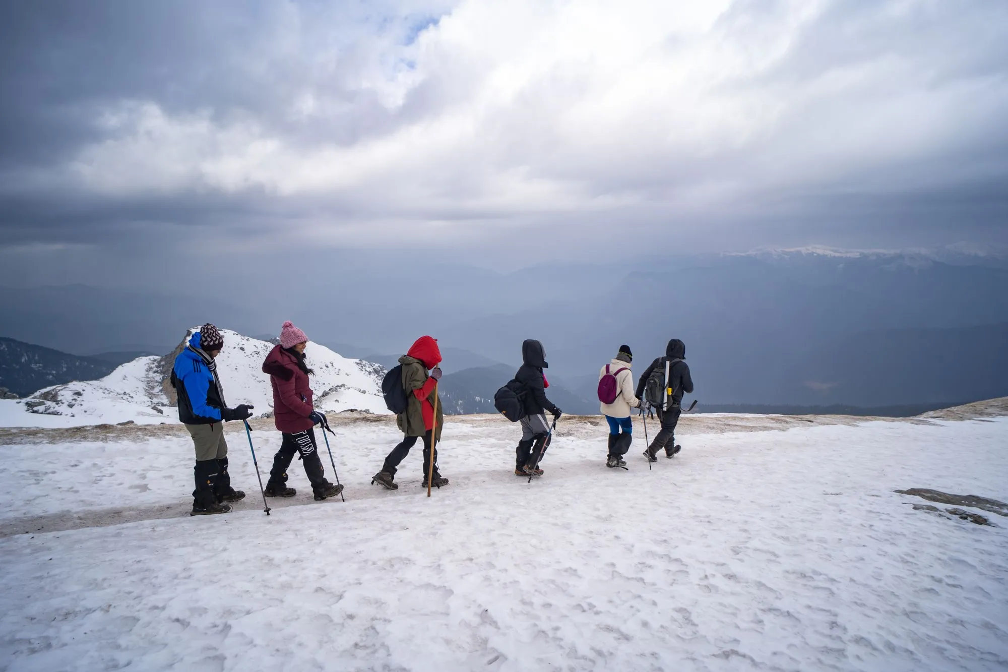 Trekkers walking through snow towards summit